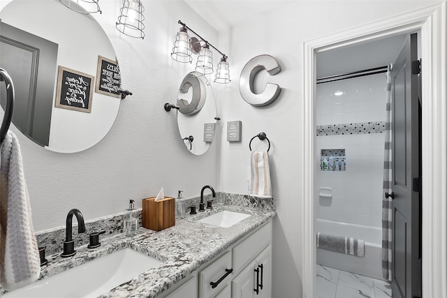 bathroom featuring tiled shower / bath and vanity