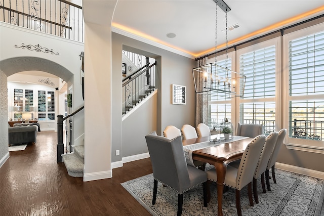 dining space featuring crown molding, a chandelier, and dark wood-type flooring