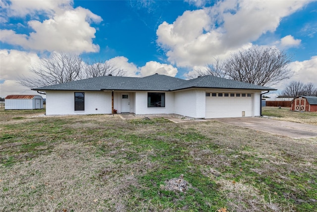 ranch-style home with a shed, a garage, and a front yard