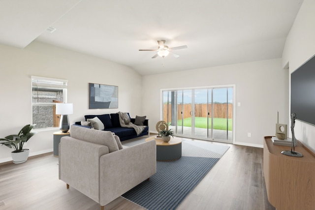 living room featuring lofted ceiling, hardwood / wood-style floors, and ceiling fan