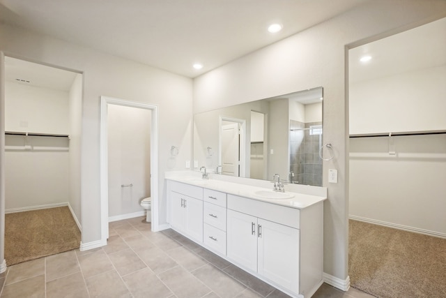 bathroom featuring vanity, tile patterned flooring, toilet, and walk in shower