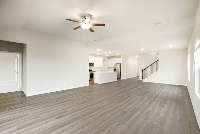 unfurnished living room with ceiling fan, lofted ceiling, sink, and light wood-type flooring