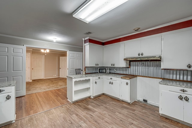 kitchen with white cabinetry, crown molding, kitchen peninsula, and light wood-type flooring