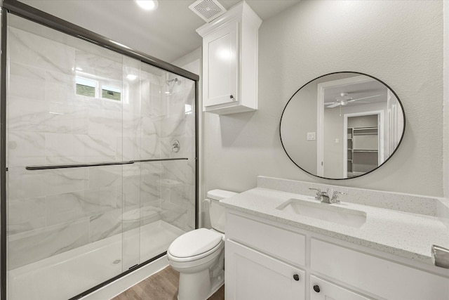 bathroom with vanity, hardwood / wood-style flooring, toilet, and walk in shower