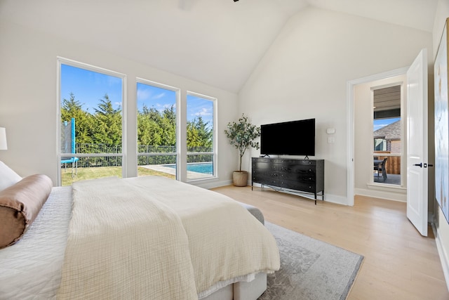 bedroom featuring high vaulted ceiling and light hardwood / wood-style floors