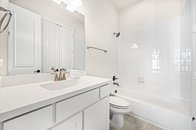 full bathroom with tiled shower / bath, vanity, and toilet