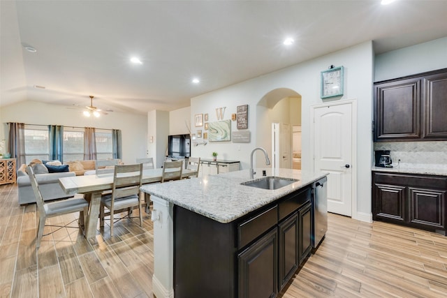 kitchen featuring dishwasher, an island with sink, sink, and light hardwood / wood-style floors