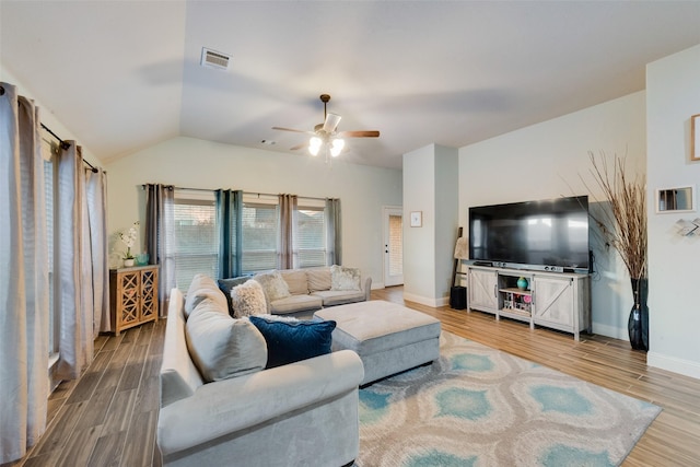 living room featuring ceiling fan, wood-type flooring, and vaulted ceiling