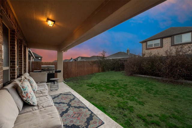 yard at dusk with outdoor lounge area and a patio