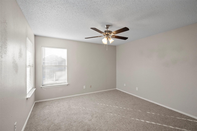 carpeted spare room featuring ceiling fan and a textured ceiling