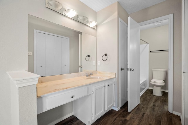 full bathroom with vanity, hardwood / wood-style floors, shower / bathing tub combination, and toilet