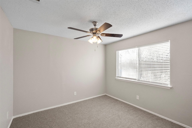 carpeted empty room featuring ceiling fan and a textured ceiling