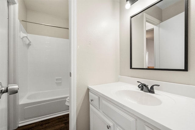 full bathroom featuring vanity, hardwood / wood-style floors, shower / bathtub combination, and toilet