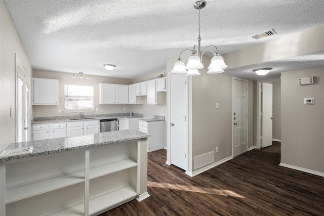 kitchen with white cabinetry, sink, decorative light fixtures, and stainless steel dishwasher