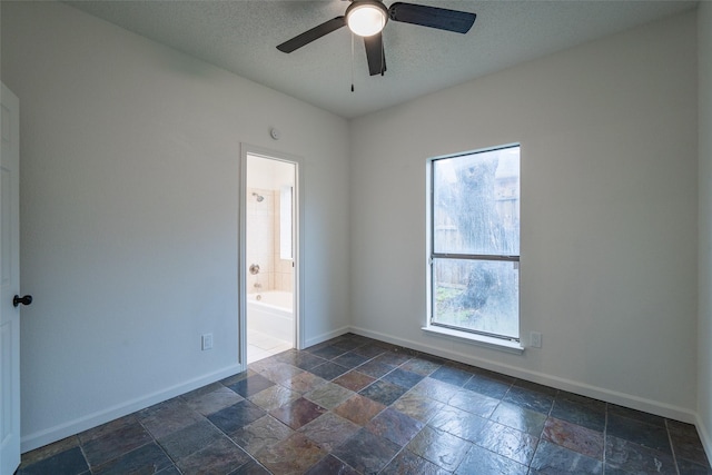 spare room featuring ceiling fan and a textured ceiling