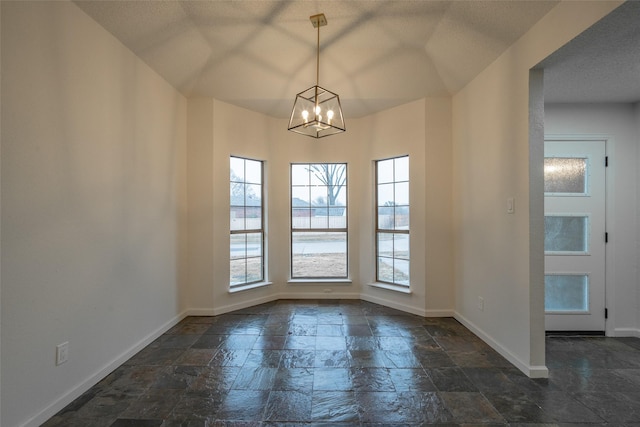 spare room featuring an inviting chandelier and a textured ceiling