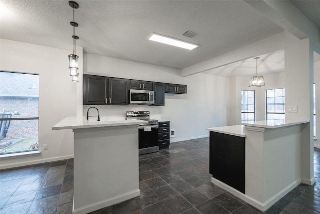 kitchen with stainless steel appliances, decorative light fixtures, a textured ceiling, and kitchen peninsula