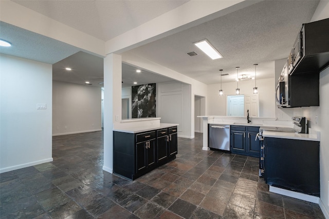 kitchen featuring sink, kitchen peninsula, a textured ceiling, and appliances with stainless steel finishes