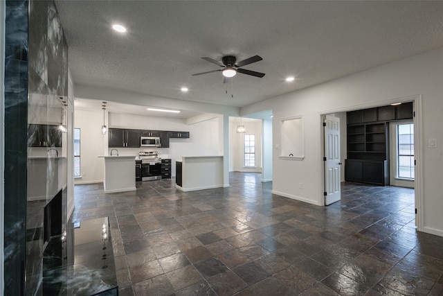 unfurnished living room with a textured ceiling and ceiling fan