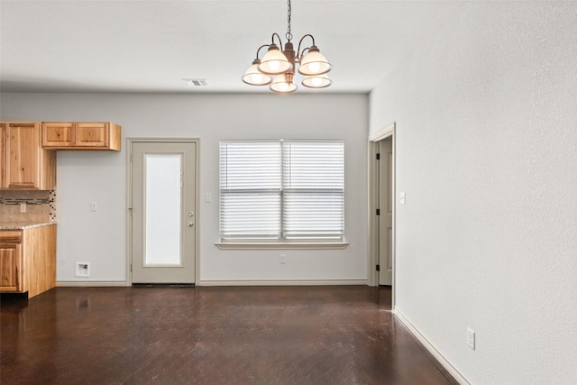 unfurnished dining area with concrete flooring, an inviting chandelier, visible vents, and baseboards