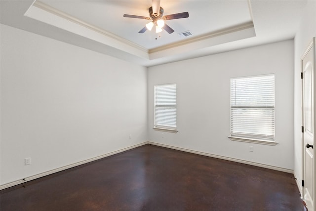 unfurnished room with plenty of natural light, a raised ceiling, visible vents, and baseboards