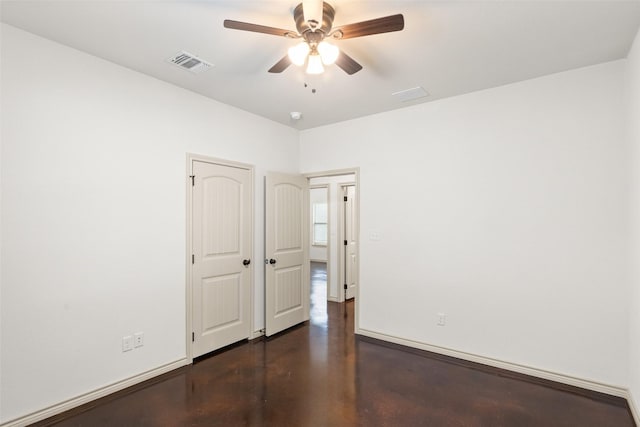 empty room with baseboards, concrete flooring, visible vents, and a ceiling fan