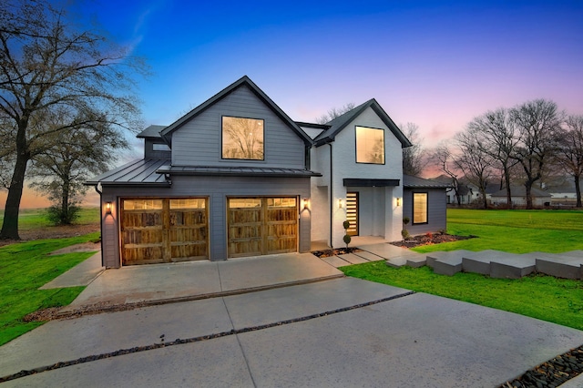 view of front of home with a garage and a lawn