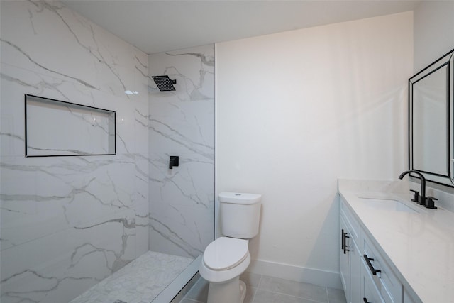 bathroom with vanity, toilet, and a tile shower