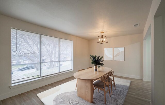 spare room featuring light hardwood / wood-style floors and a chandelier