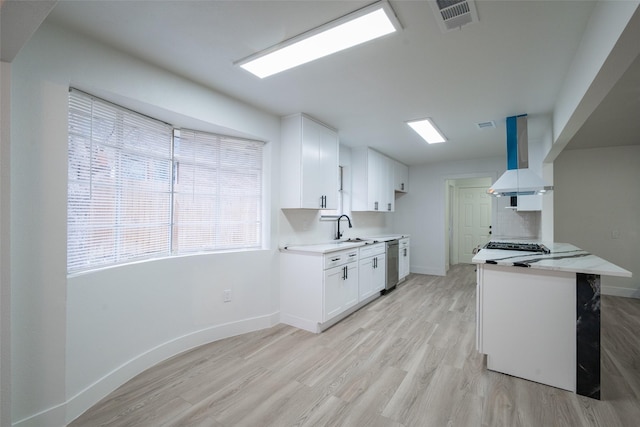 kitchen with sink, white cabinetry, island range hood, light hardwood / wood-style floors, and stainless steel dishwasher