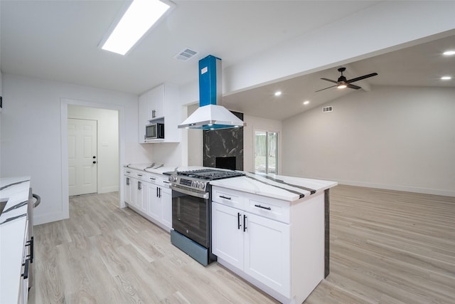 kitchen featuring white cabinetry, island exhaust hood, and appliances with stainless steel finishes