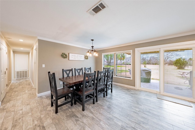 dining area with crown molding, a chandelier, and light hardwood / wood-style flooring