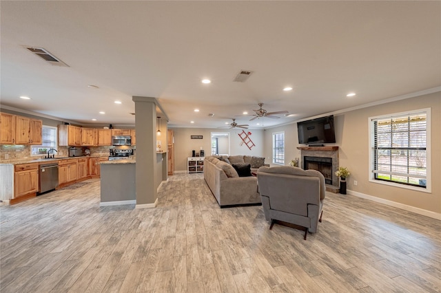 living room with crown molding, sink, ceiling fan, and light hardwood / wood-style floors