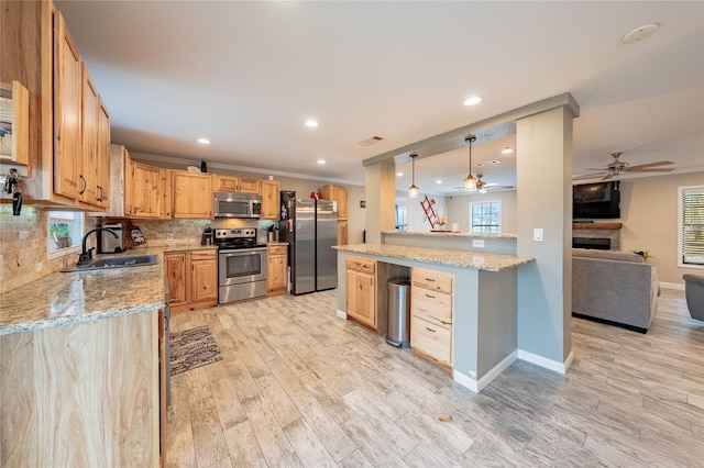 kitchen featuring backsplash, stainless steel appliances, light stone countertops, decorative light fixtures, and light wood-type flooring