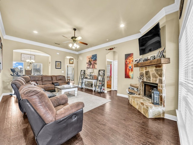 living room featuring crown molding, dark hardwood / wood-style floors, ceiling fan with notable chandelier, and a fireplace