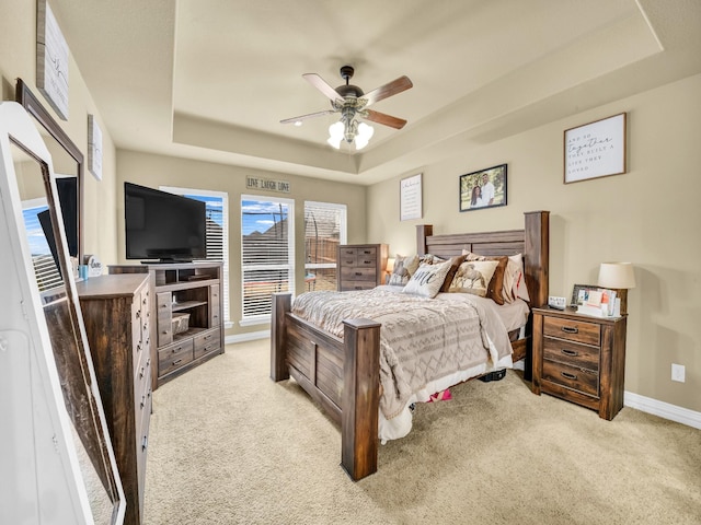 carpeted bedroom featuring ceiling fan, a tray ceiling, and access to outside