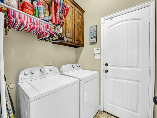 washroom with cabinets and washer and dryer