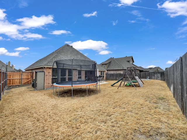 view of yard with a playground and a trampoline