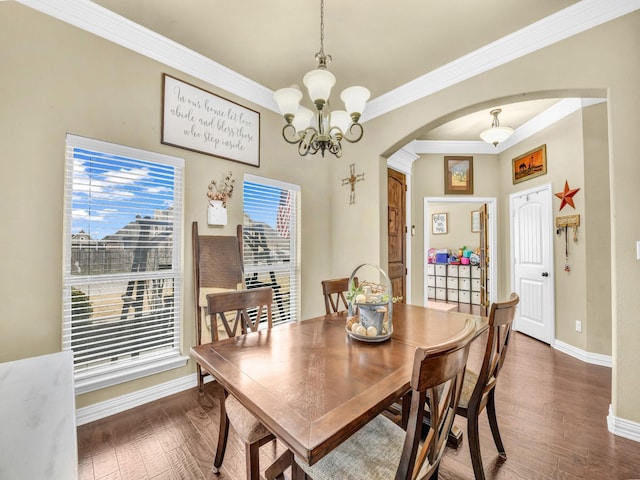 dining space with crown molding, dark hardwood / wood-style floors, and a chandelier