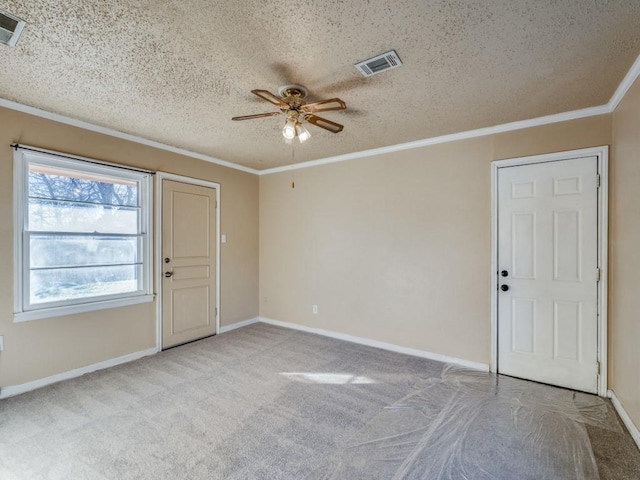 carpeted entryway with ceiling fan, crown molding, and a textured ceiling