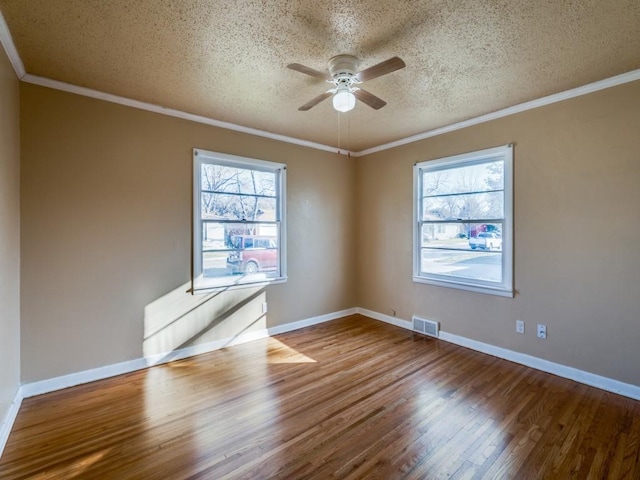 spare room featuring crown molding, a healthy amount of sunlight, hardwood / wood-style floors, and ceiling fan