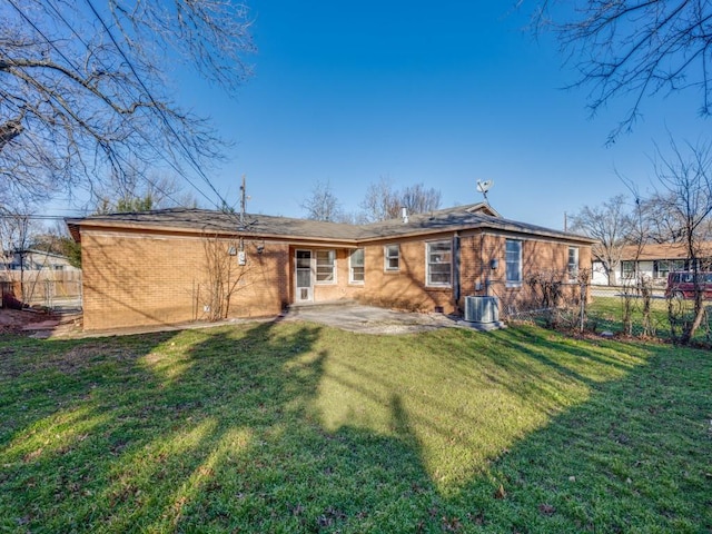 back of property with a yard, a patio area, and central air condition unit