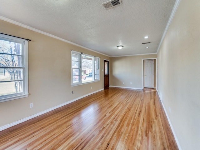 unfurnished room with crown molding, a textured ceiling, and light wood-type flooring