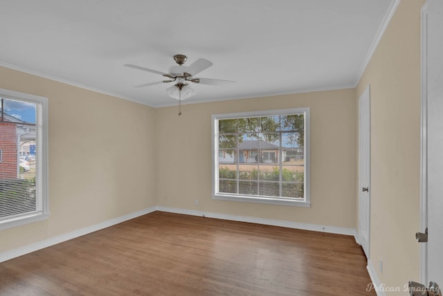 spare room featuring a ceiling fan, baseboards, ornamental molding, and wood finished floors