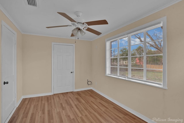 interior space featuring baseboards, visible vents, light wood-style flooring, and ornamental molding