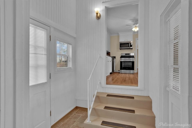 stairs featuring ceiling fan