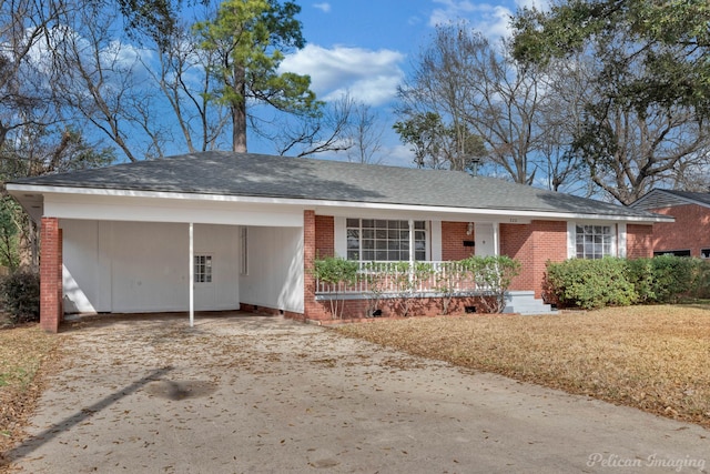 single story home with a shingled roof, concrete driveway, an attached carport, covered porch, and brick siding