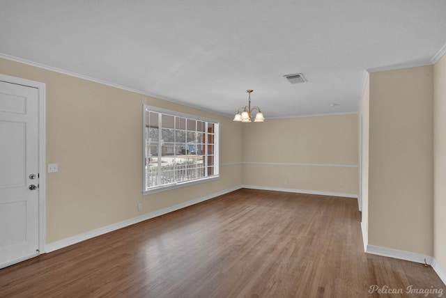 interior space featuring baseboards, ornamental molding, wood finished floors, and a notable chandelier