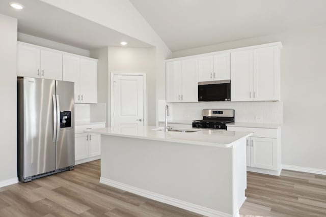 kitchen featuring appliances with stainless steel finishes, sink, a center island with sink, and white cabinets