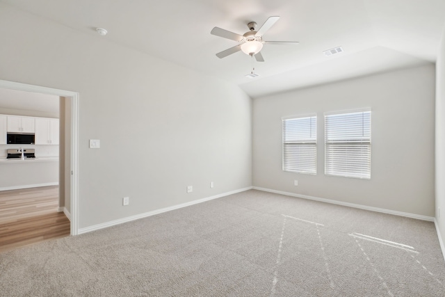 carpeted empty room featuring ceiling fan and lofted ceiling